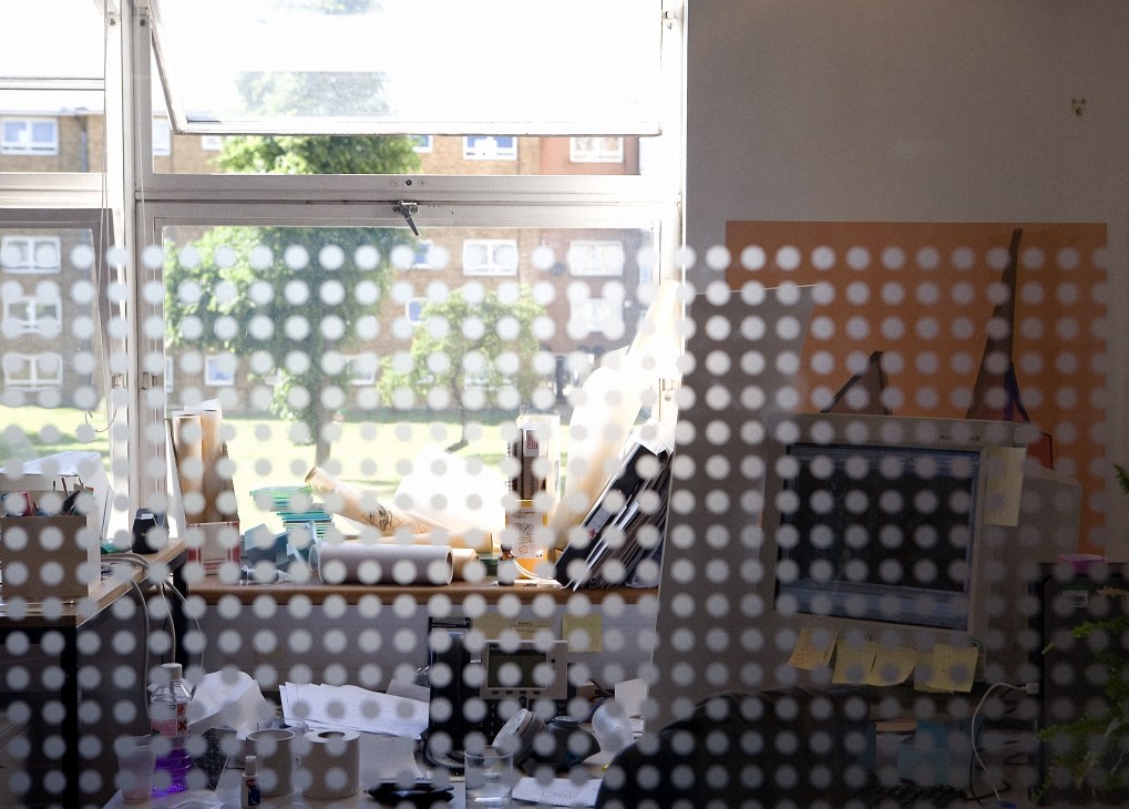 Arup's London office interior showing a work desk by a window with perforated metal screening.