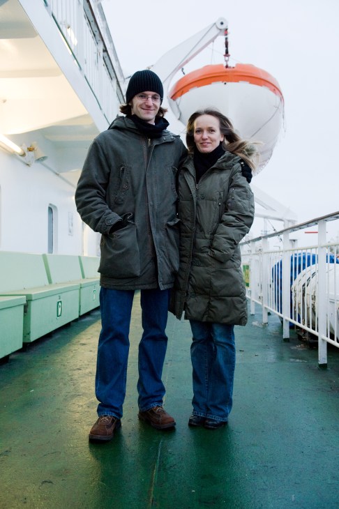 Two passengers stand on the deck of M/S Gabriella ferry, with a lifeboat visible behind them.