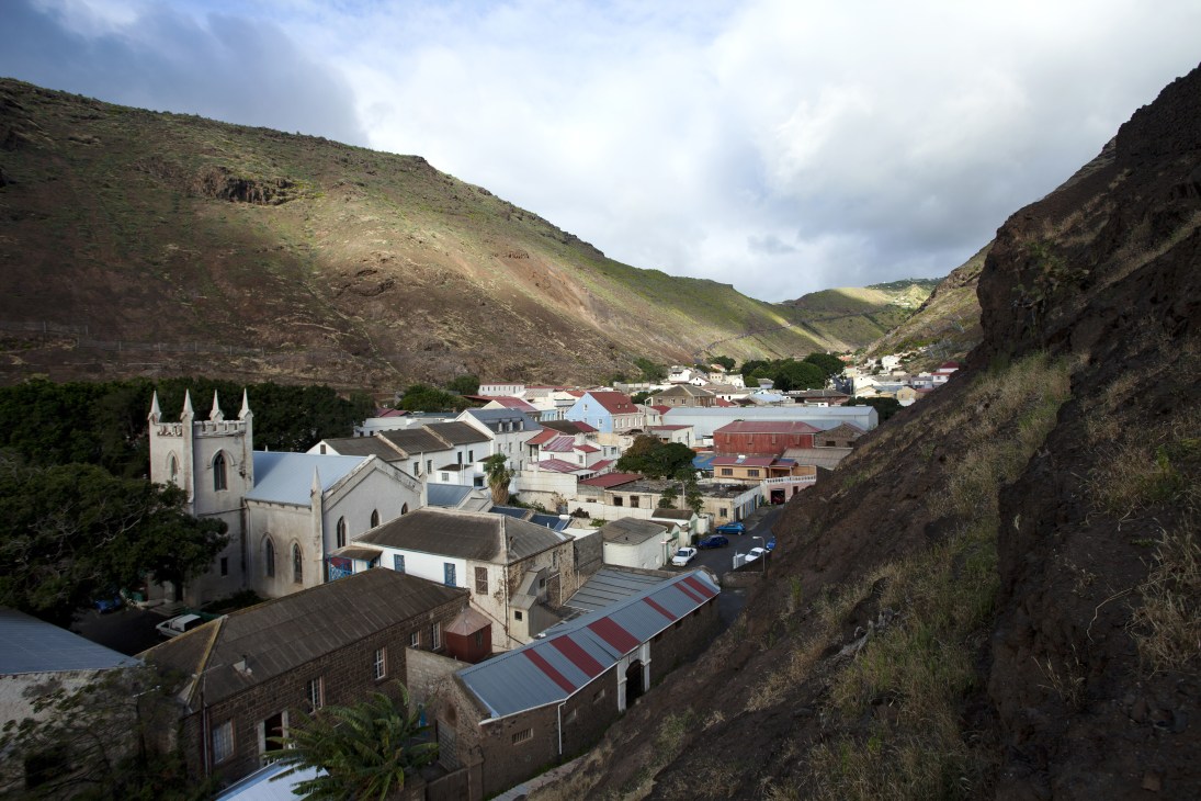 Jamestown, St Helena nestled in a valley between steep cliffs with colorful buildings and a white church.