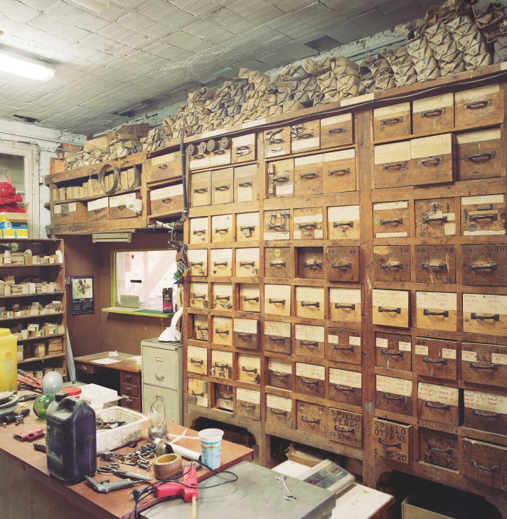Wooden storage drawers and shelves with metal handles at Sangermani boatyard stockroom.