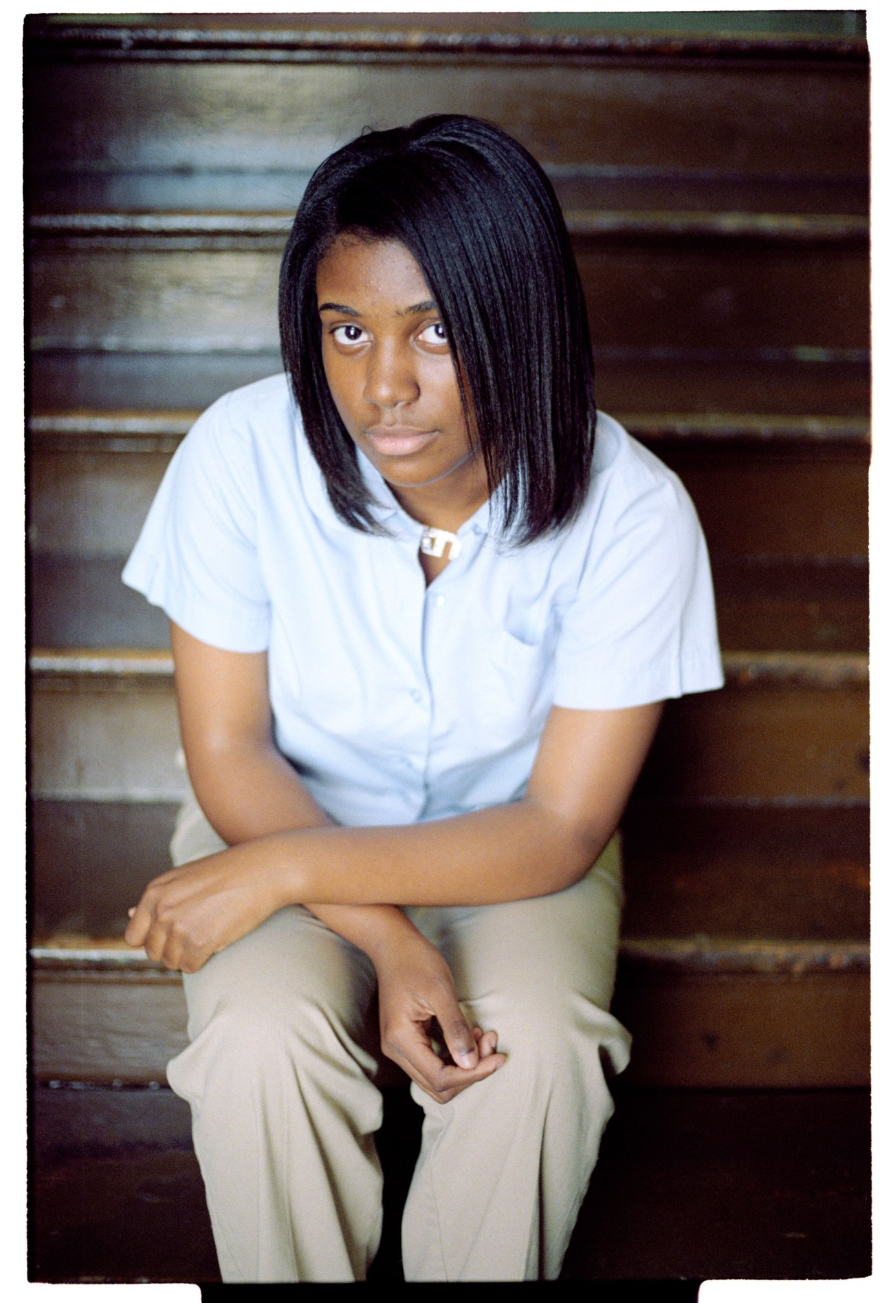 Portrait of Annisha Johnson, a young International High School student in New Orleans, sitting on wooden steps.