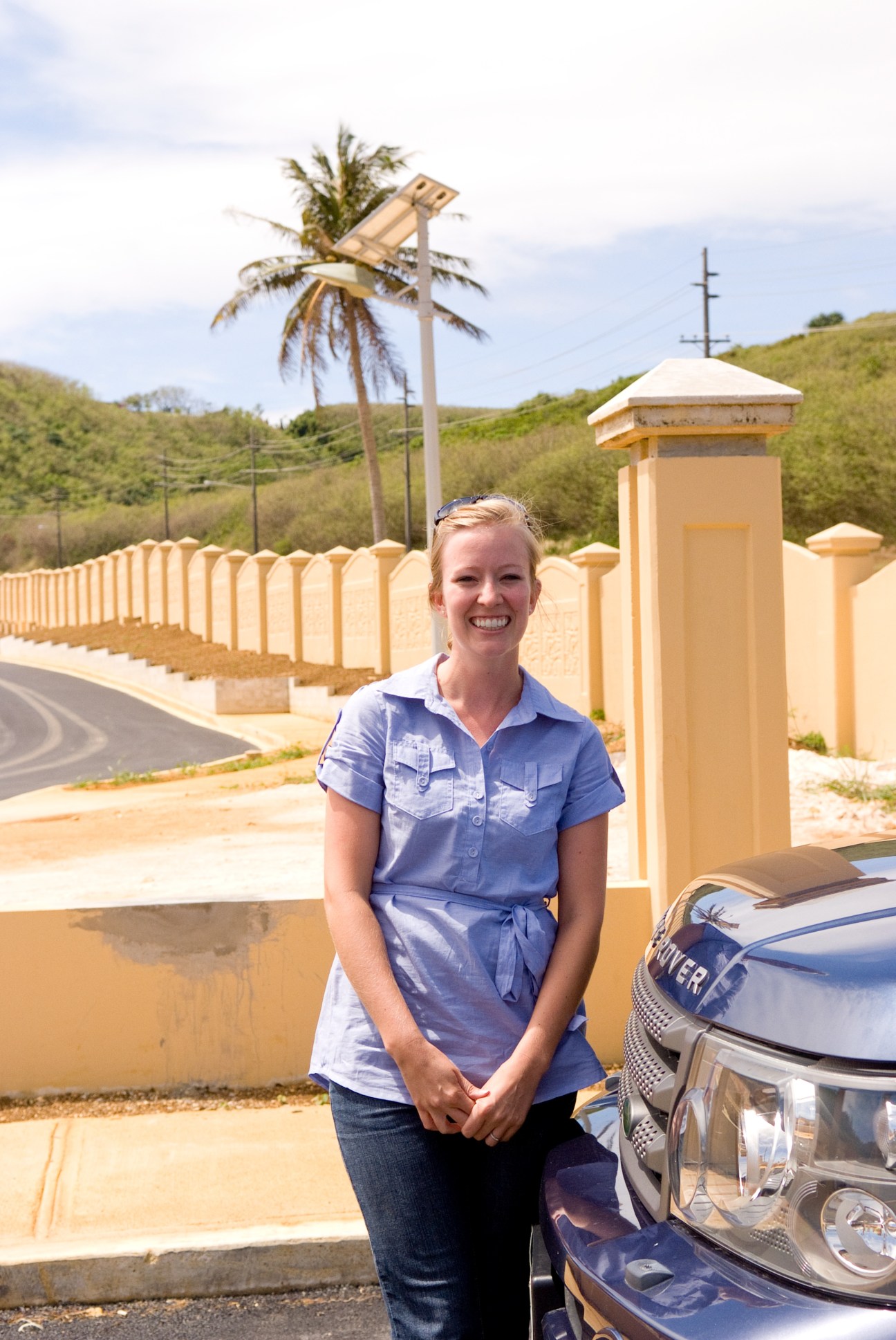 Stacie Gensic, administrator at The Laguna development, stands smiling outside the gated entrance to the Pago Bay eco-homes project.