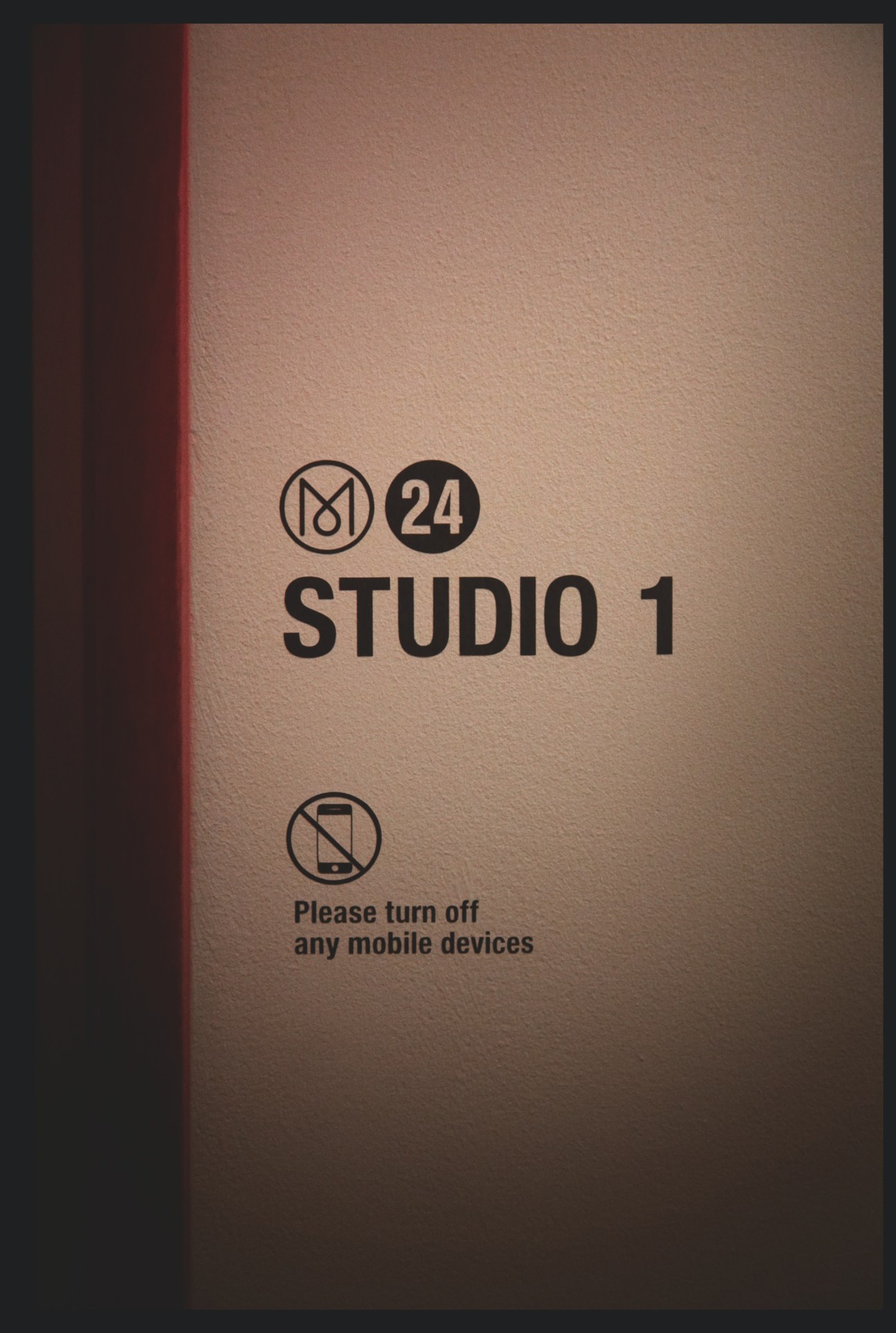 Monocle 24 Studio 1 door sign with mobile device off icon and instruction text.