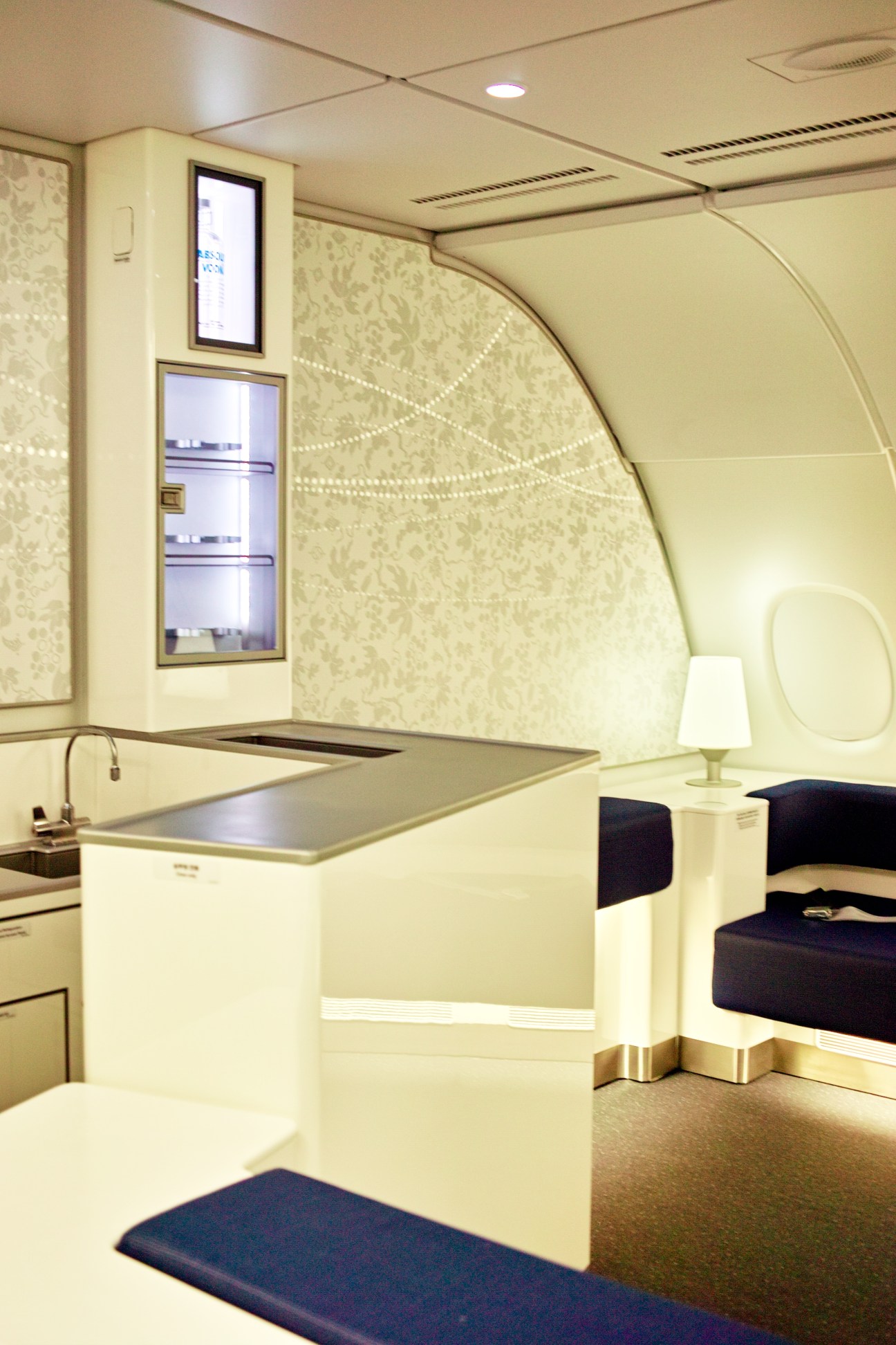 Interior of Korean Air's A380 Celestial bar and lounge with cream-colored walls, built-in counter, and modern furnishings.