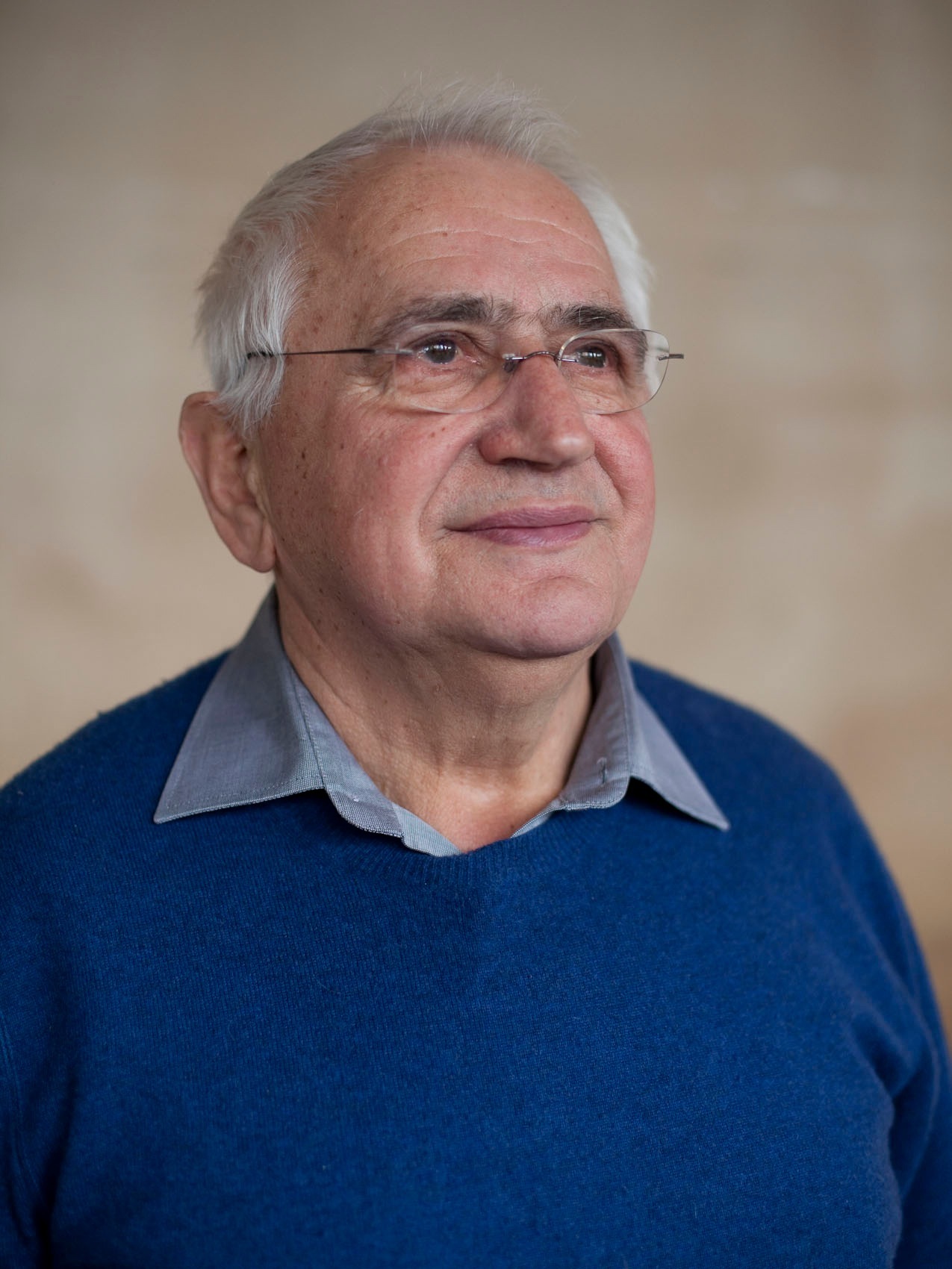 Portrait of Basim Niksic, an older man wearing glasses and a blue sweater.
