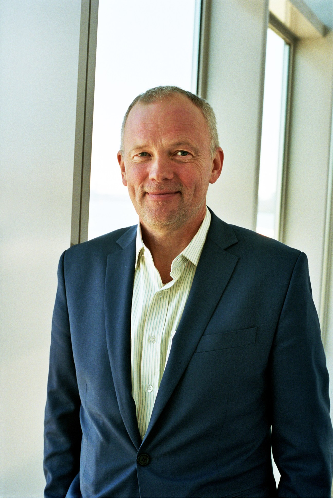 Portrait of Mogens Morgen, head of the Danish Heritage Agency, standing by a window.