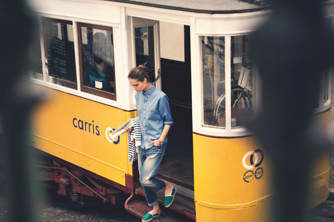 Model on a yellow Lisbon tram wearing Visvim shirt, G-Star jeans, Kitsuné espadrilles and Cartier watch.