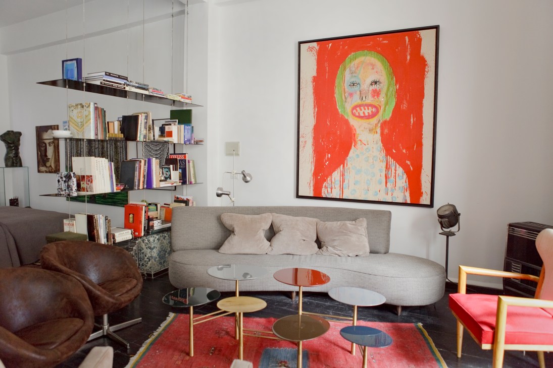 Modern living room with grey sofa, colorful artwork, and bookshelves in Toufic el Zein's home.