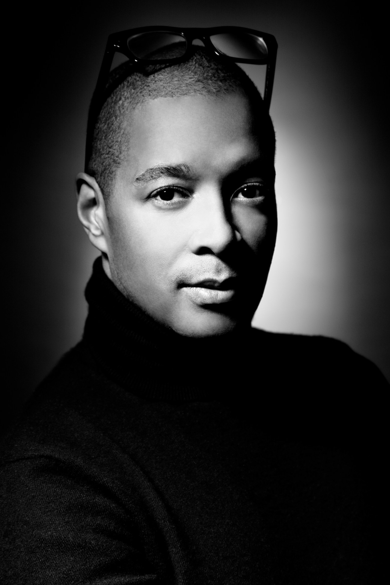 Black and white portrait of Ian Hylton, Creative Director of Ports 1961, wearing glasses pushed up on his head.