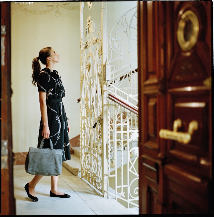 Model Carina Pichler in Louis Vuitton dress and Isaac Reina bag in ornate Madrid apartment hallway.