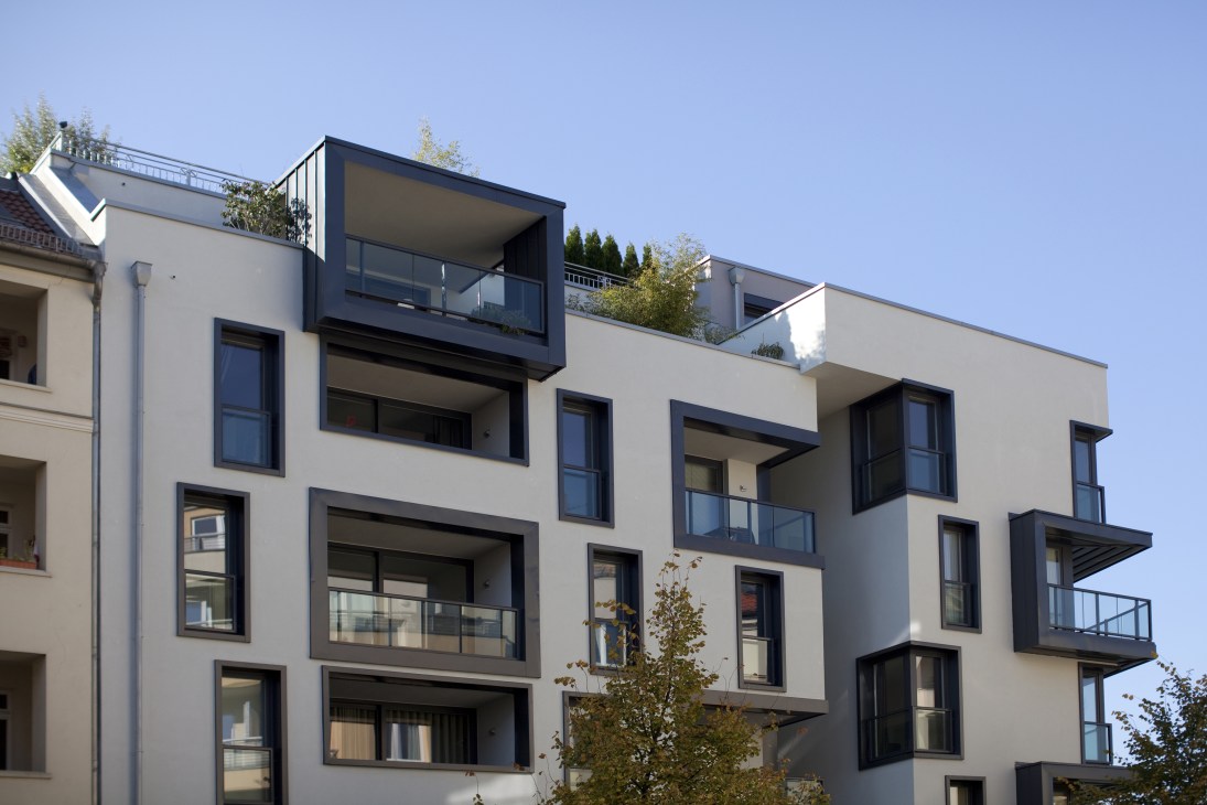 Modern residential building with white and dark grey facade and multiple balconies on Gartenstrasse