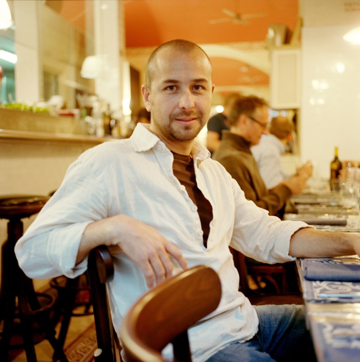Vladimir Soto sits at a restaurant table with an orange-lit interior at Ristorante Bastimento.