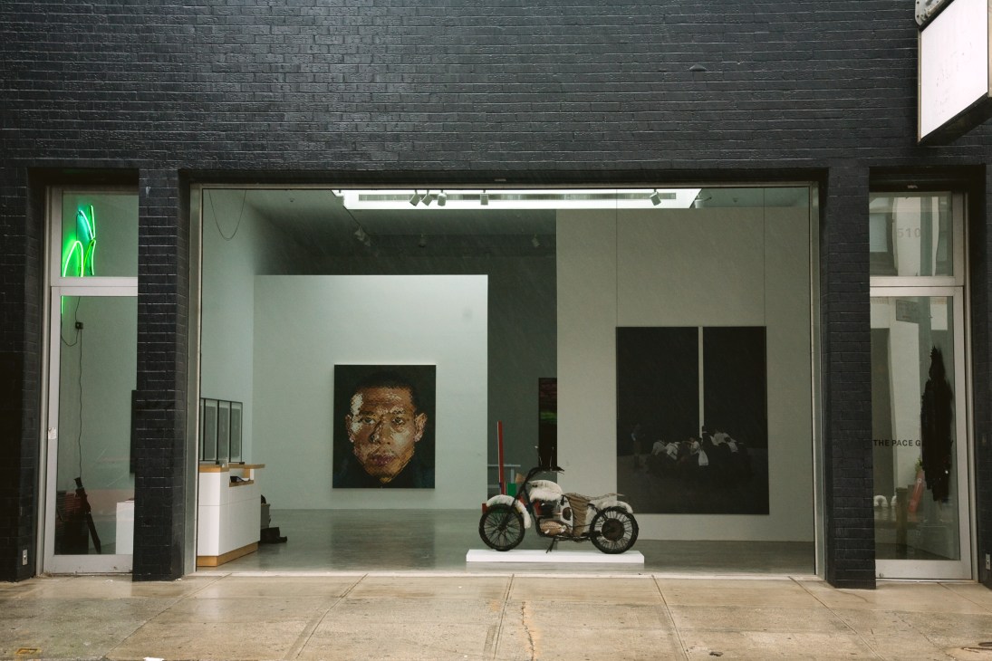 Pace Gallery storefront at 510 West 25th Street displaying contemporary artworks including a portrait painting and motorcycle sculpture.