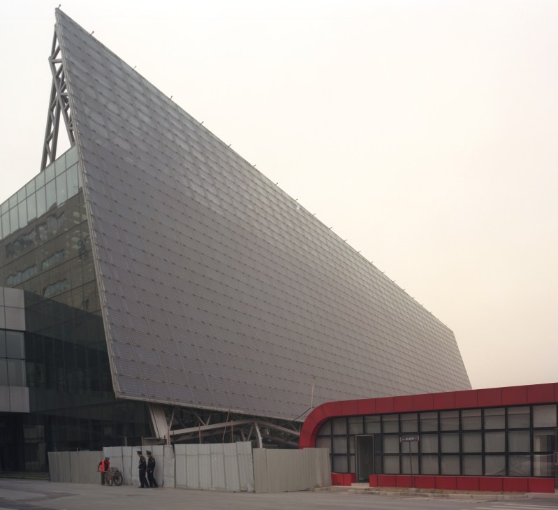 Suntech Power's modern industrial facility featuring a large angular metallic facade and red entrance structure in Wuxi.