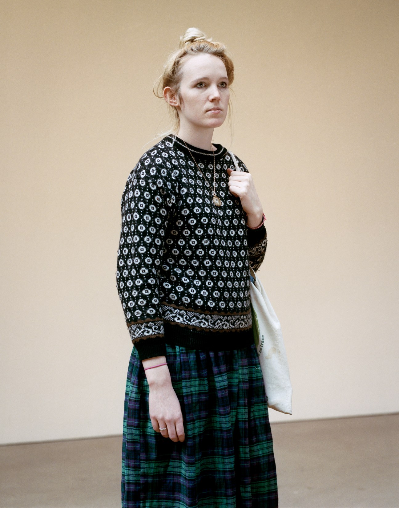 Central Saint Martins womenswear student Laura Mills wearing a patterned sweater and tartan skirt.