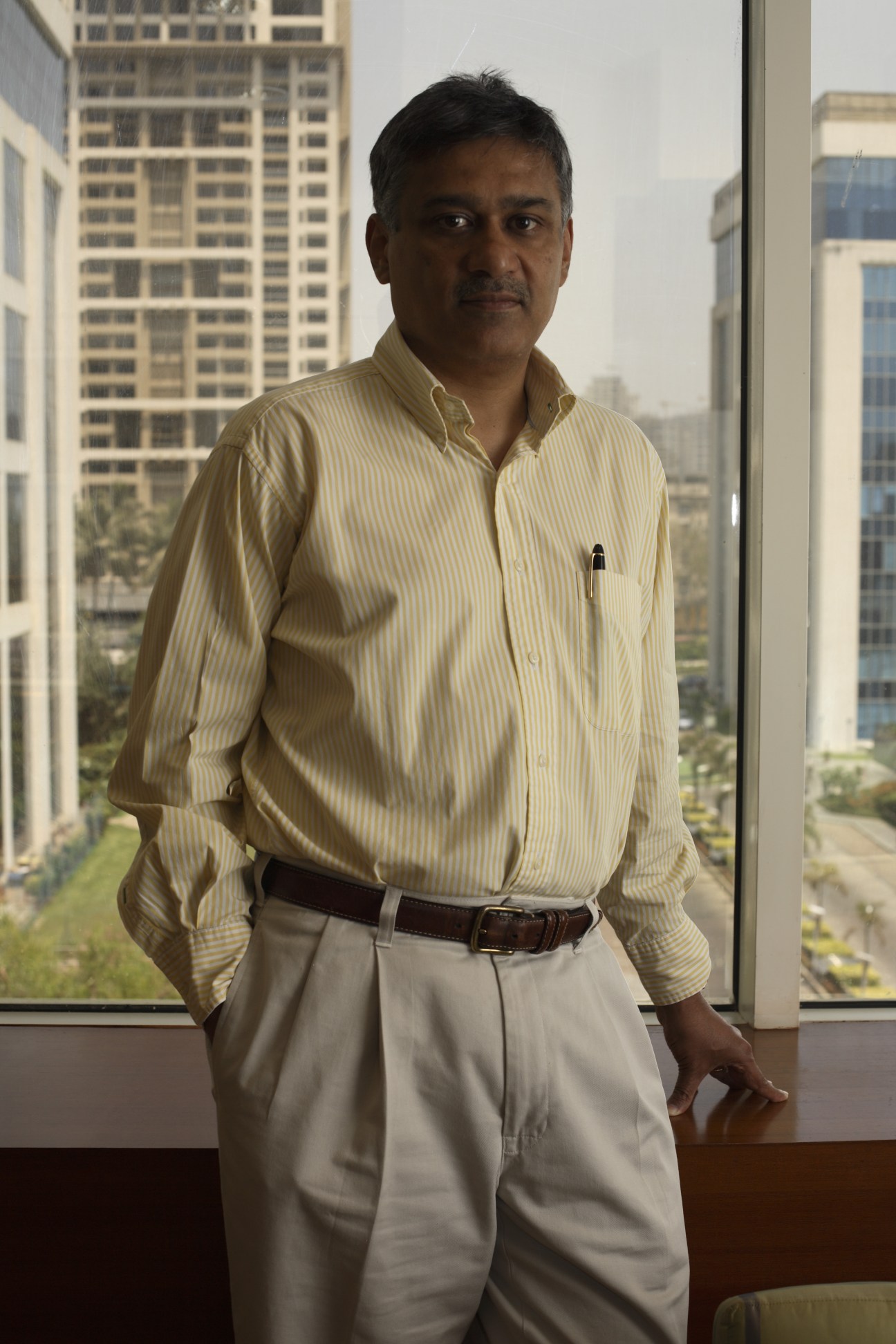 Colvyn Harris, CEO of JWT India, stands by a window overlooking Mumbai's skyline in a high-rise office.