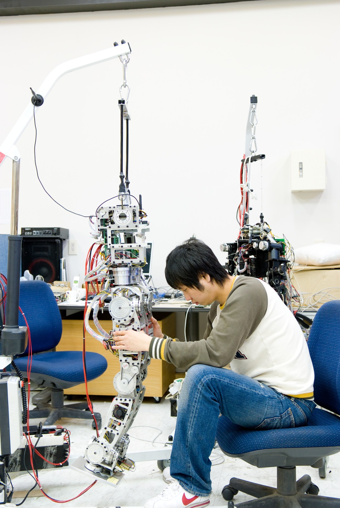 Student working on a humanoid robot prototype in a laboratory setting.