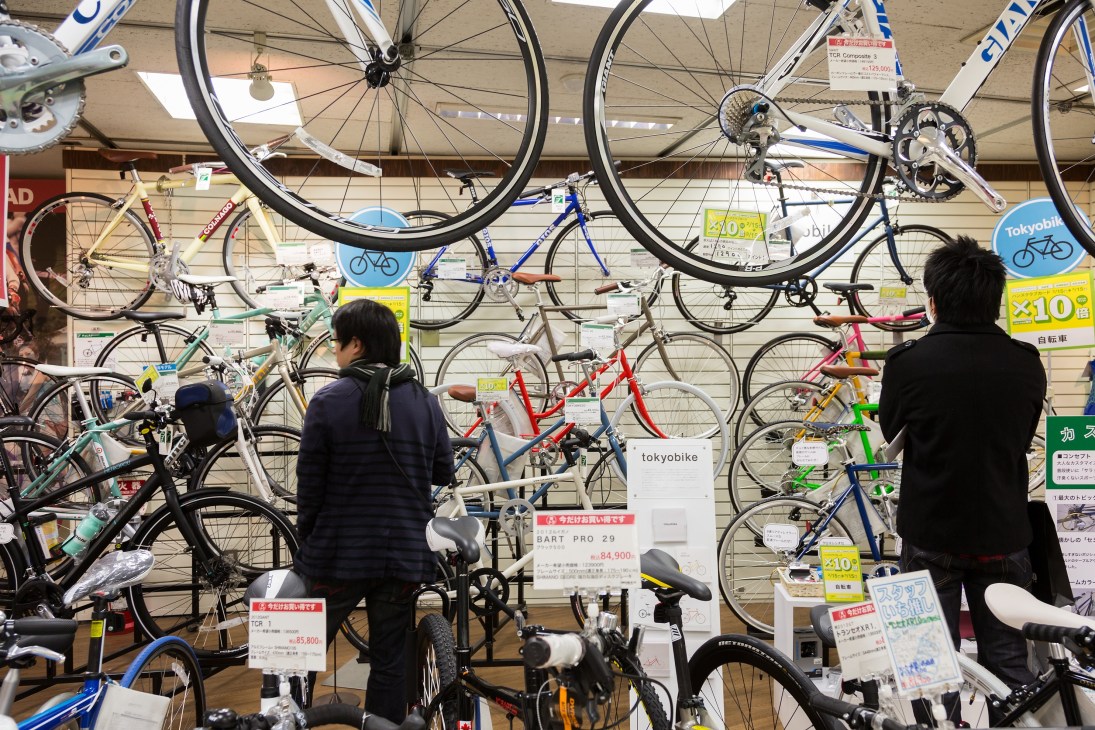 Customers browse bicycles and cycling equipment displayed on walls and floors at Tokyu Hands.