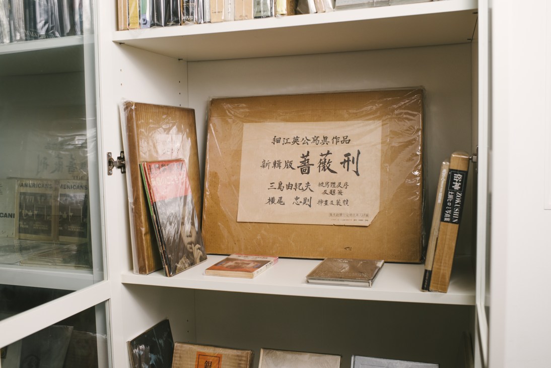 Display shelf in Bondi Books showing rare vintage books wrapped in brown paper with Japanese text labels and older volumes.