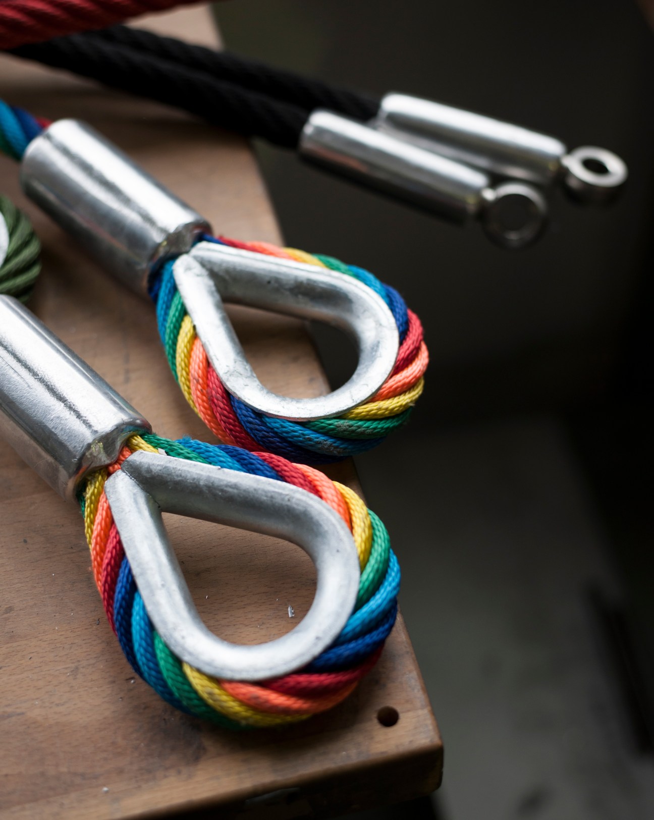 Steel bands with colorful rainbow rope reinforcing metal connector loops for Corocord playground nets.