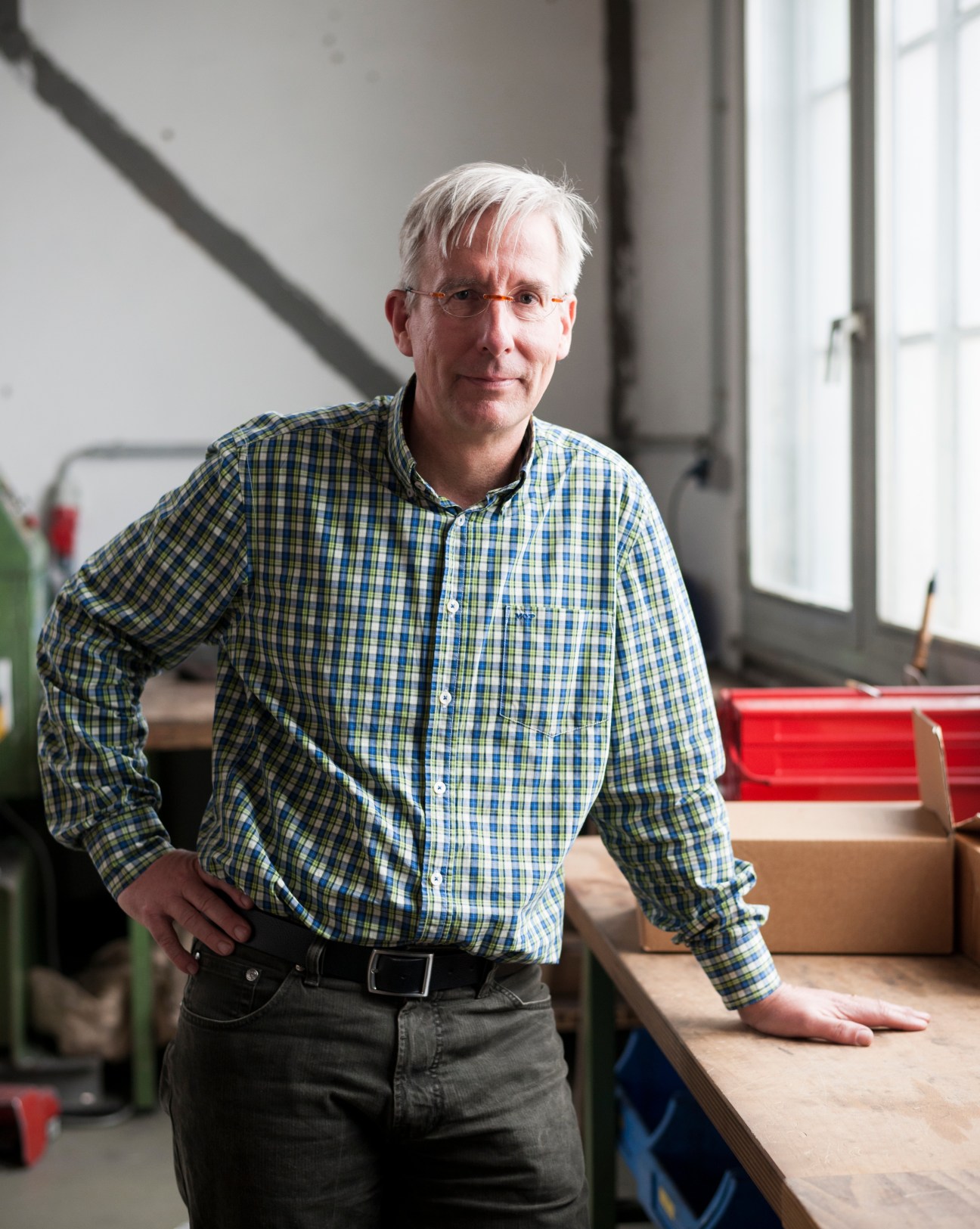 Torsten Frank, CEO of Corocord, poses in the Berlin factory with a checkered shirt.