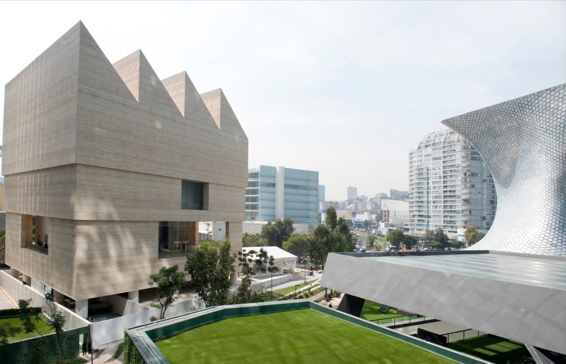 David Chipperfield's travertine Museo Jumex building with angular roof forms, alongside Mexico City's mirrored high-rises.