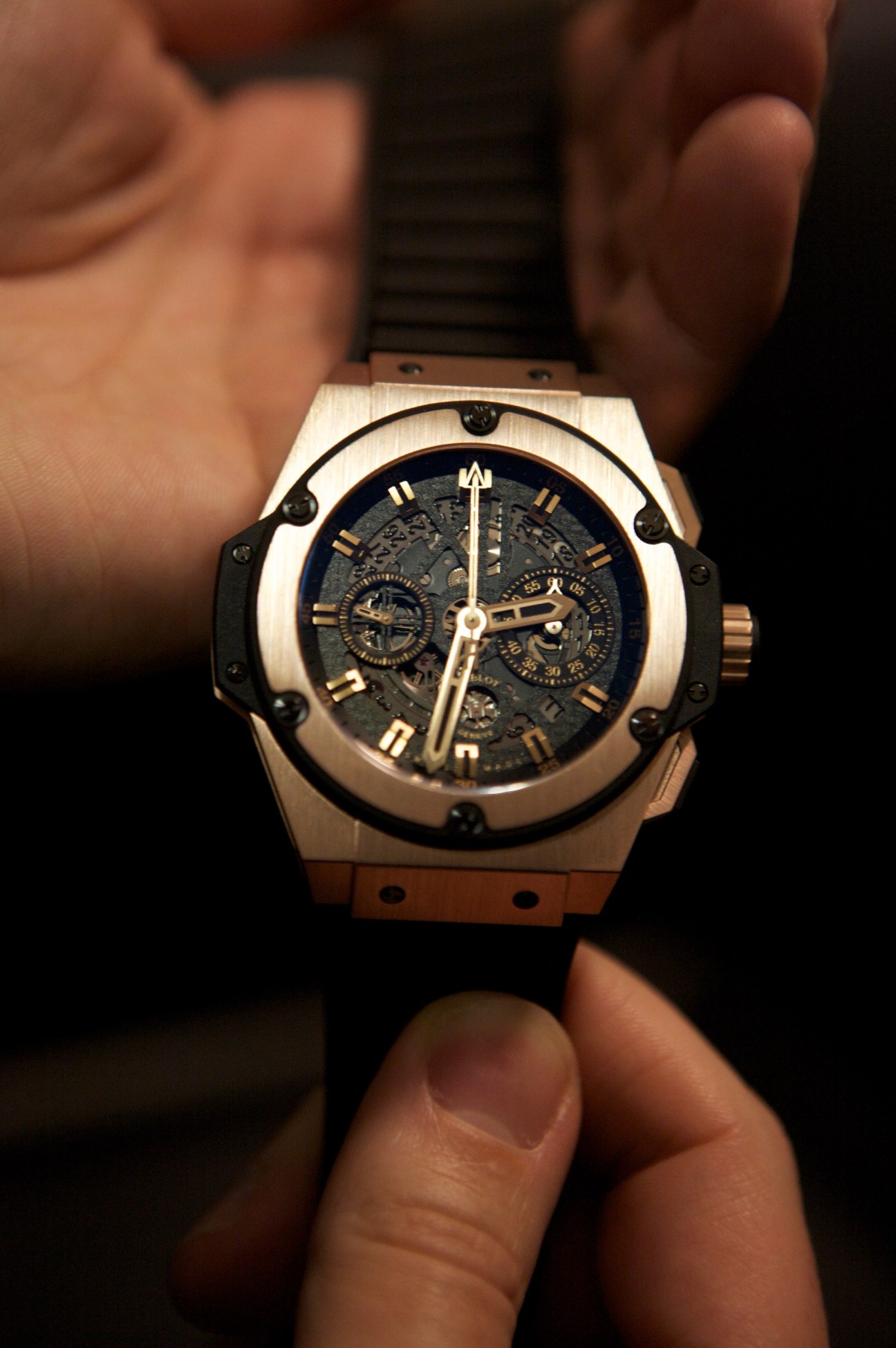 Hublot King Power watch in gold with skeleton dial held in hands.