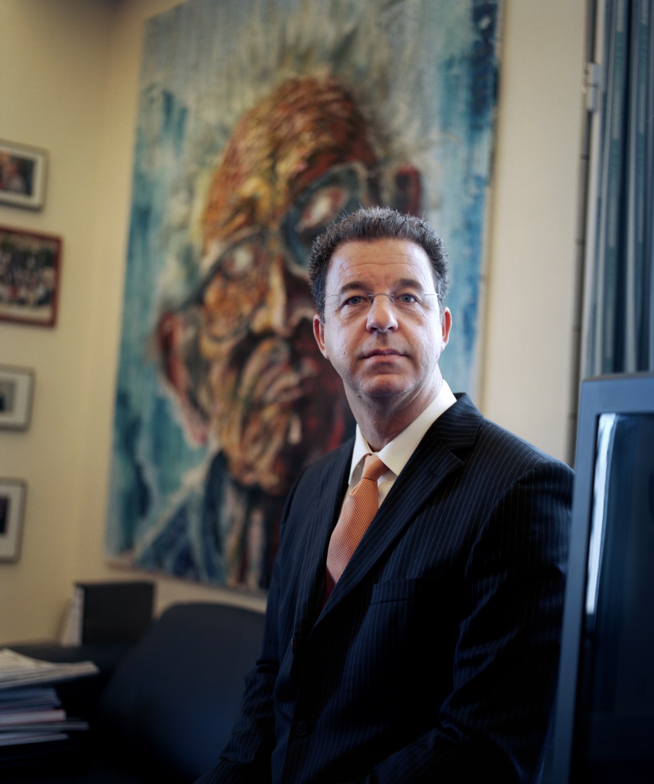 ICTY prosecutor Serge Brammertz in his office with artwork on the wall behind him.