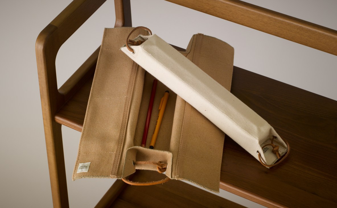 Baistone canvas cases displayed on a wooden ladder, showing neutral-toned fabric storage organizers with leather straps and writing implements.