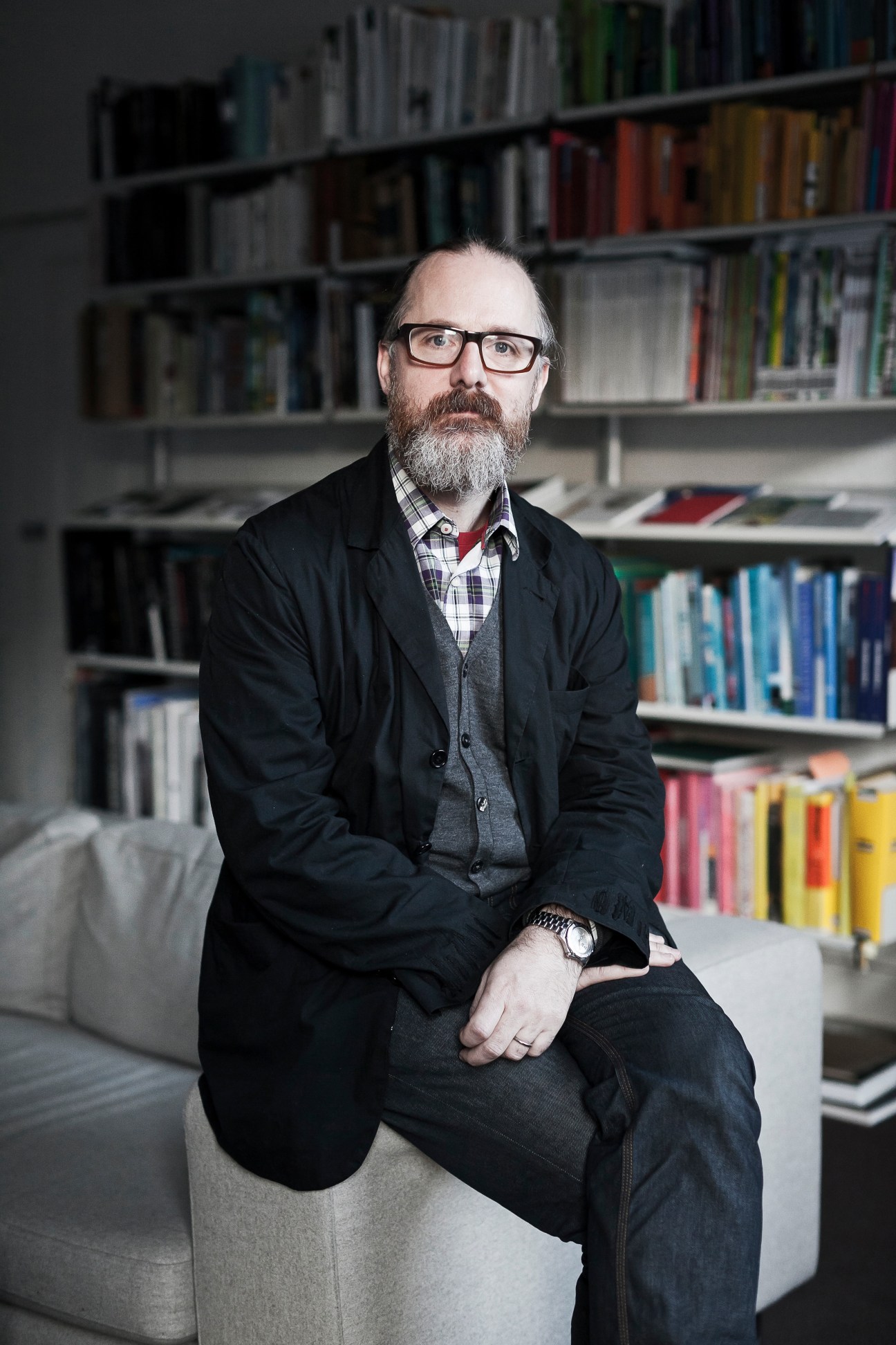 Ciarán O'Gaora, founder of Zero-G advertising firm, sitting in an office with bookshelves behind him.