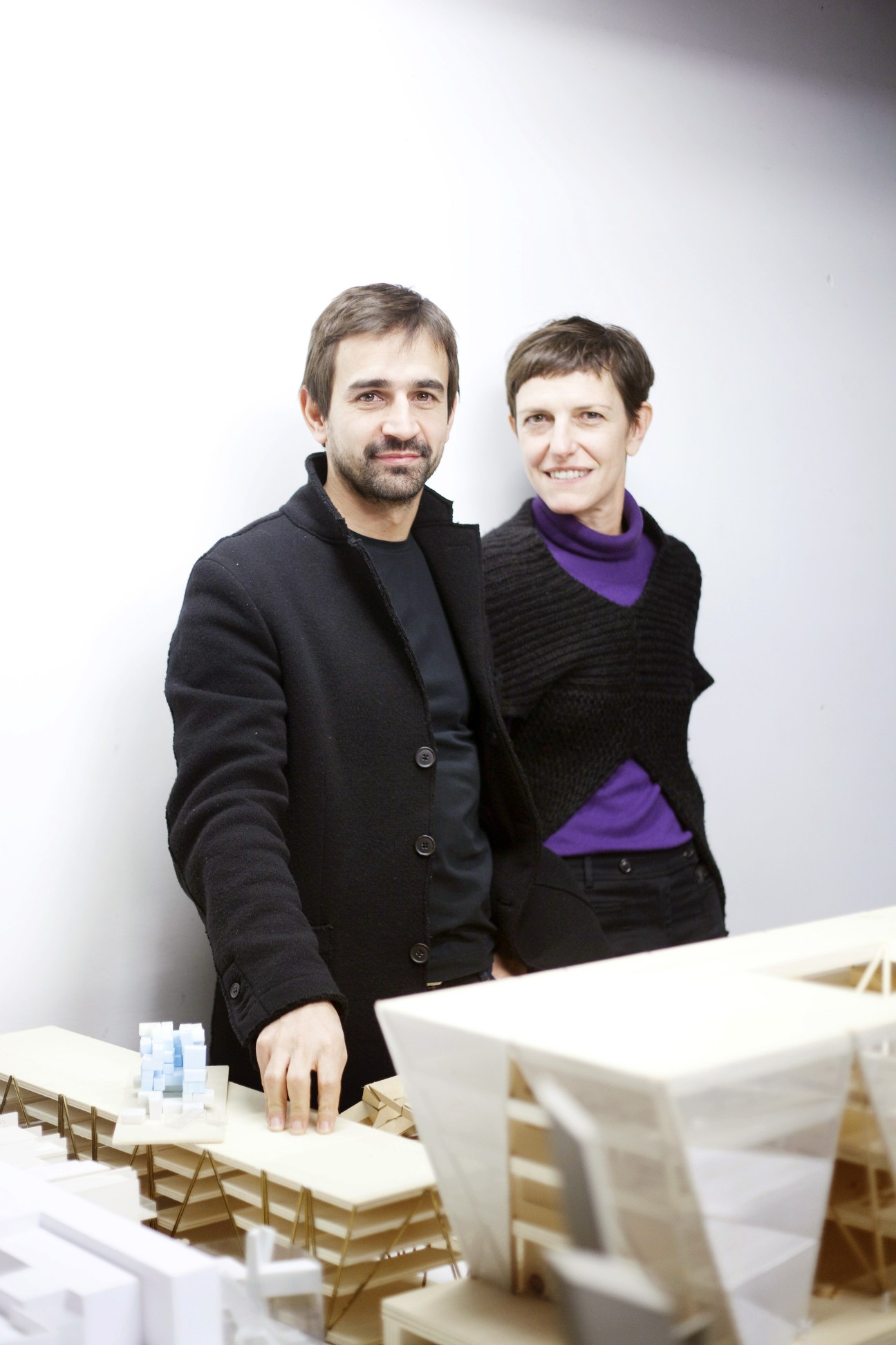 Maria Claudia Clemente and Francesco Isidori of Labics architecture practice standing behind architectural models.