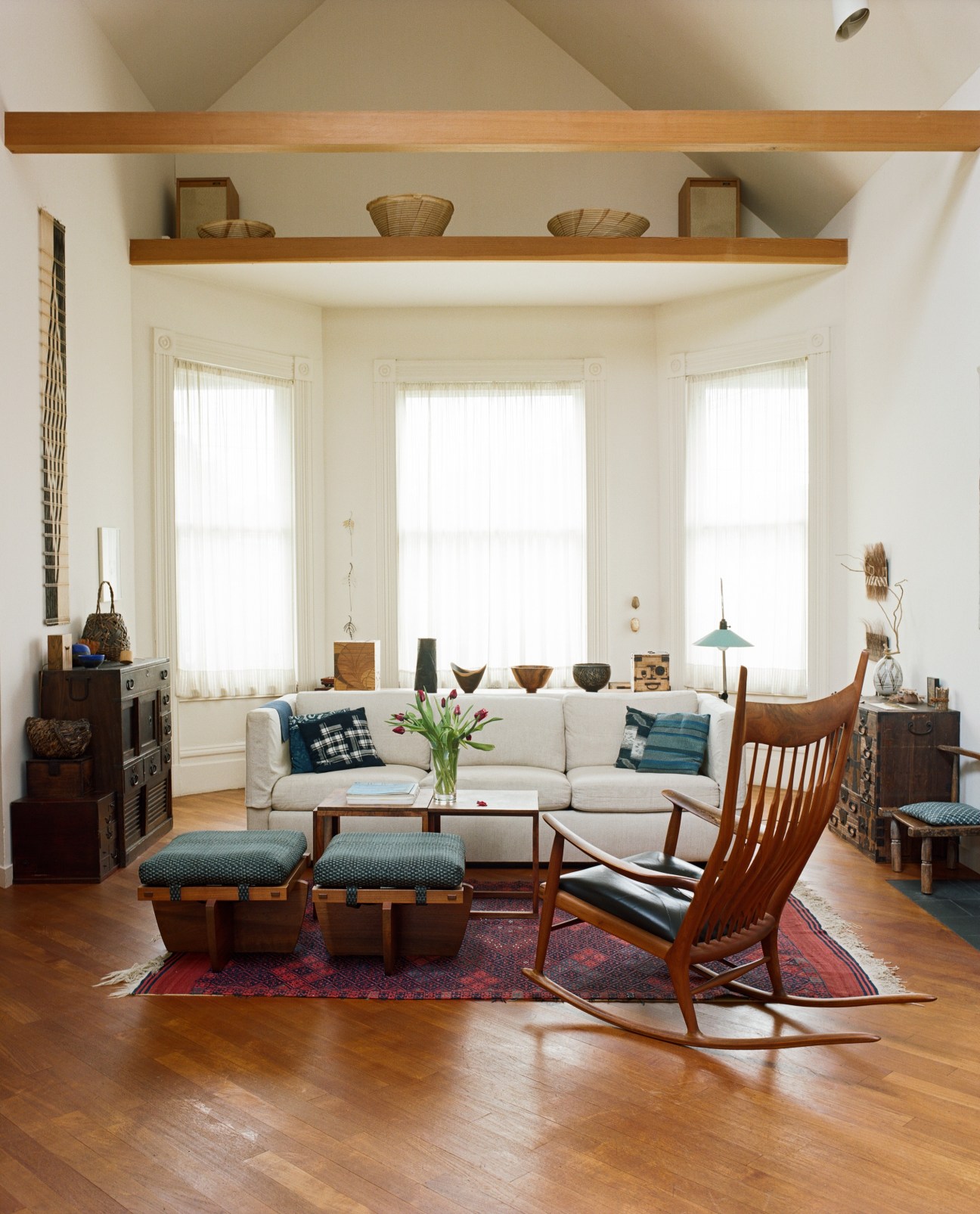 Kay Sekimachi's living room with mid-century modern furniture, cream sofa, wooden chairs, and handmade objects on shelves.
