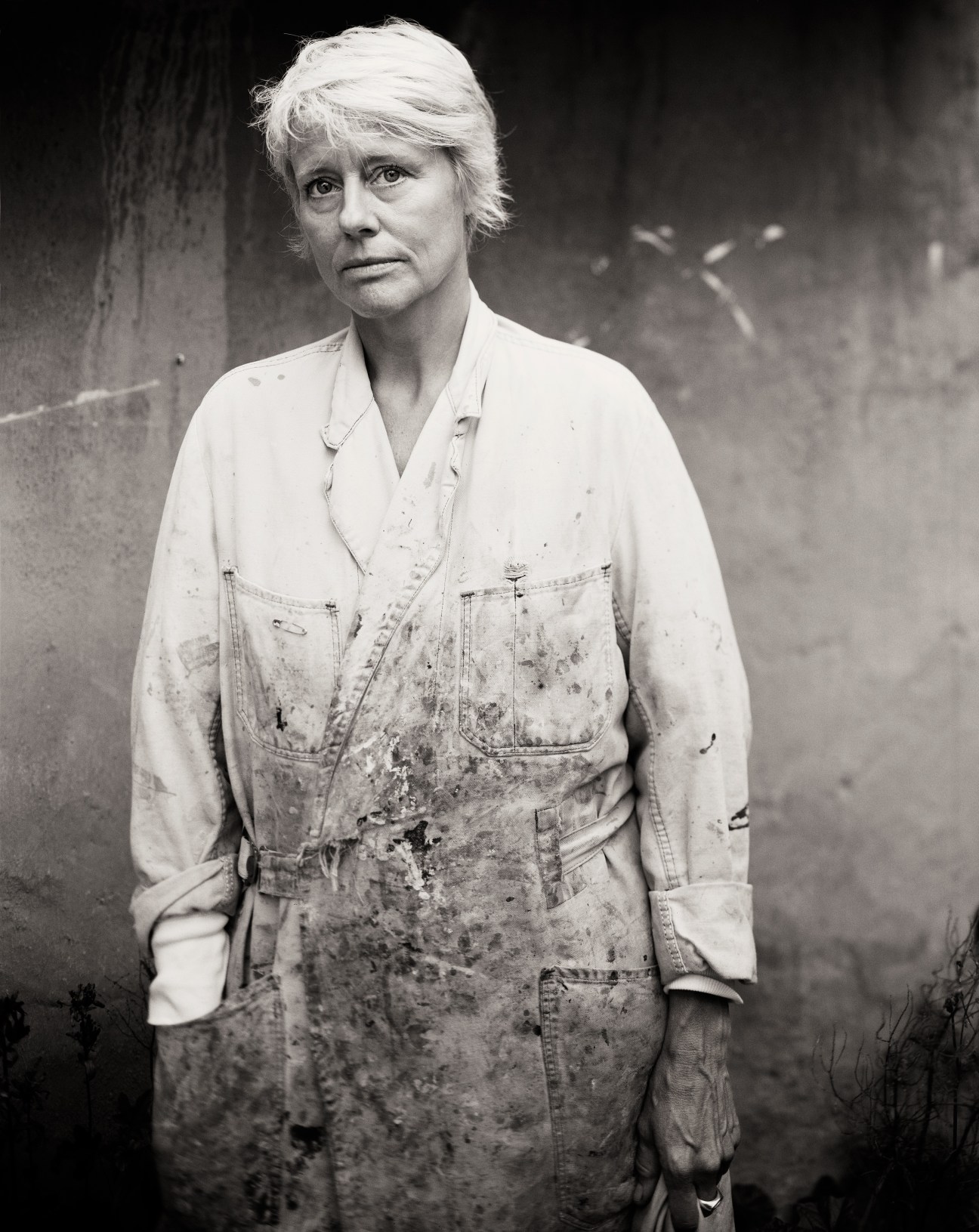 Black and white portrait of textile student Nina Stenby wearing a work apron.