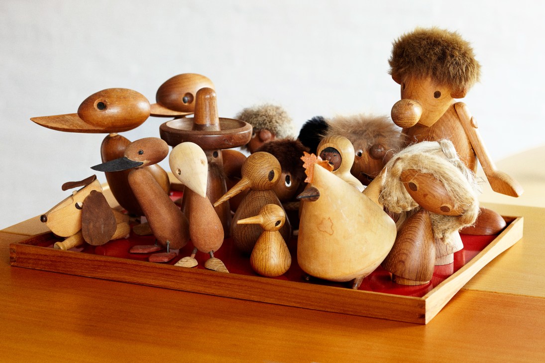 Collection of wooden animal figurines and design prototypes on a red base.
