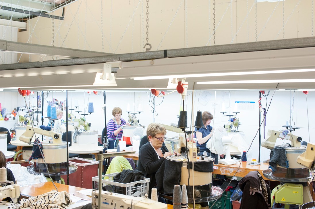 Workers at sewing machines in a bright knitwear factory in Scotland.