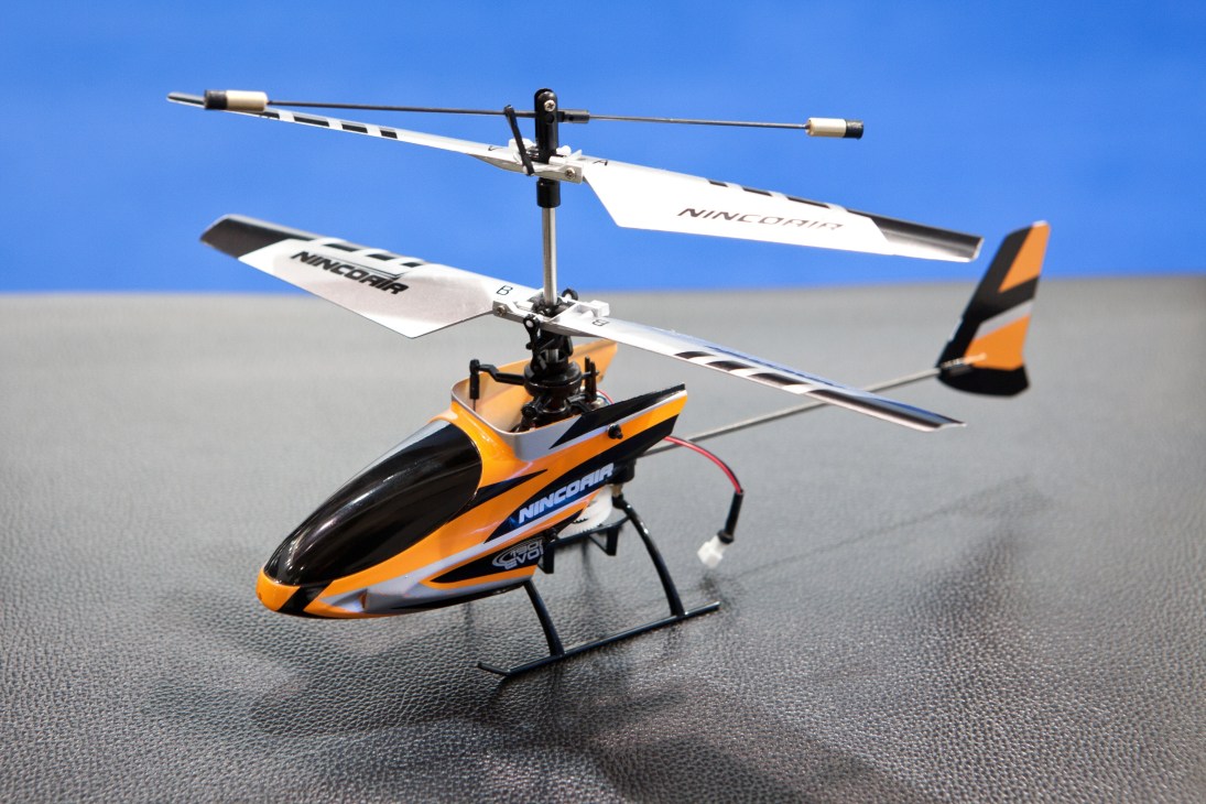 Ninco remote-controlled helicopter with orange and black body and white rotor blades.