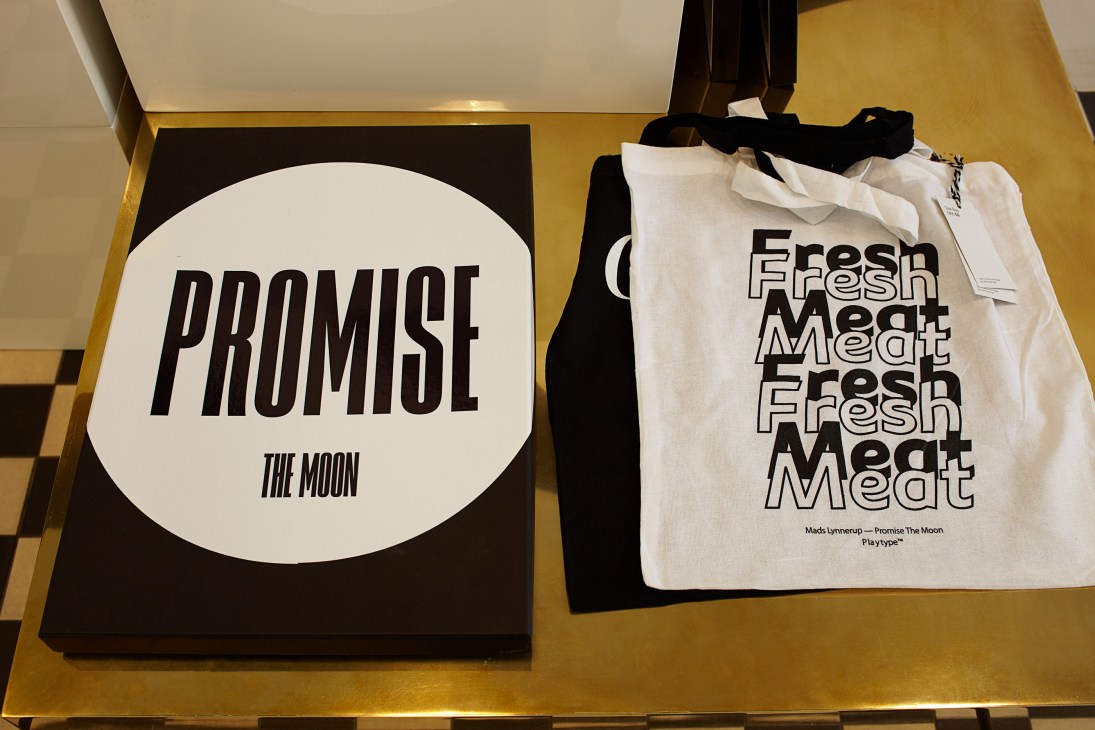 Font-themed bags displayed on a yellow surface, featuring black and white typography designs from Playtype.