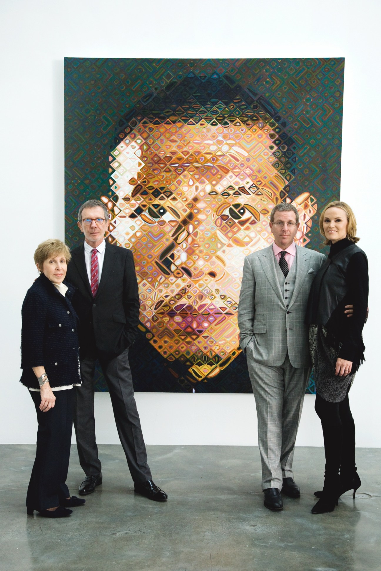 The Glimcher family stands before a colorful portrait artwork in a gallery space.