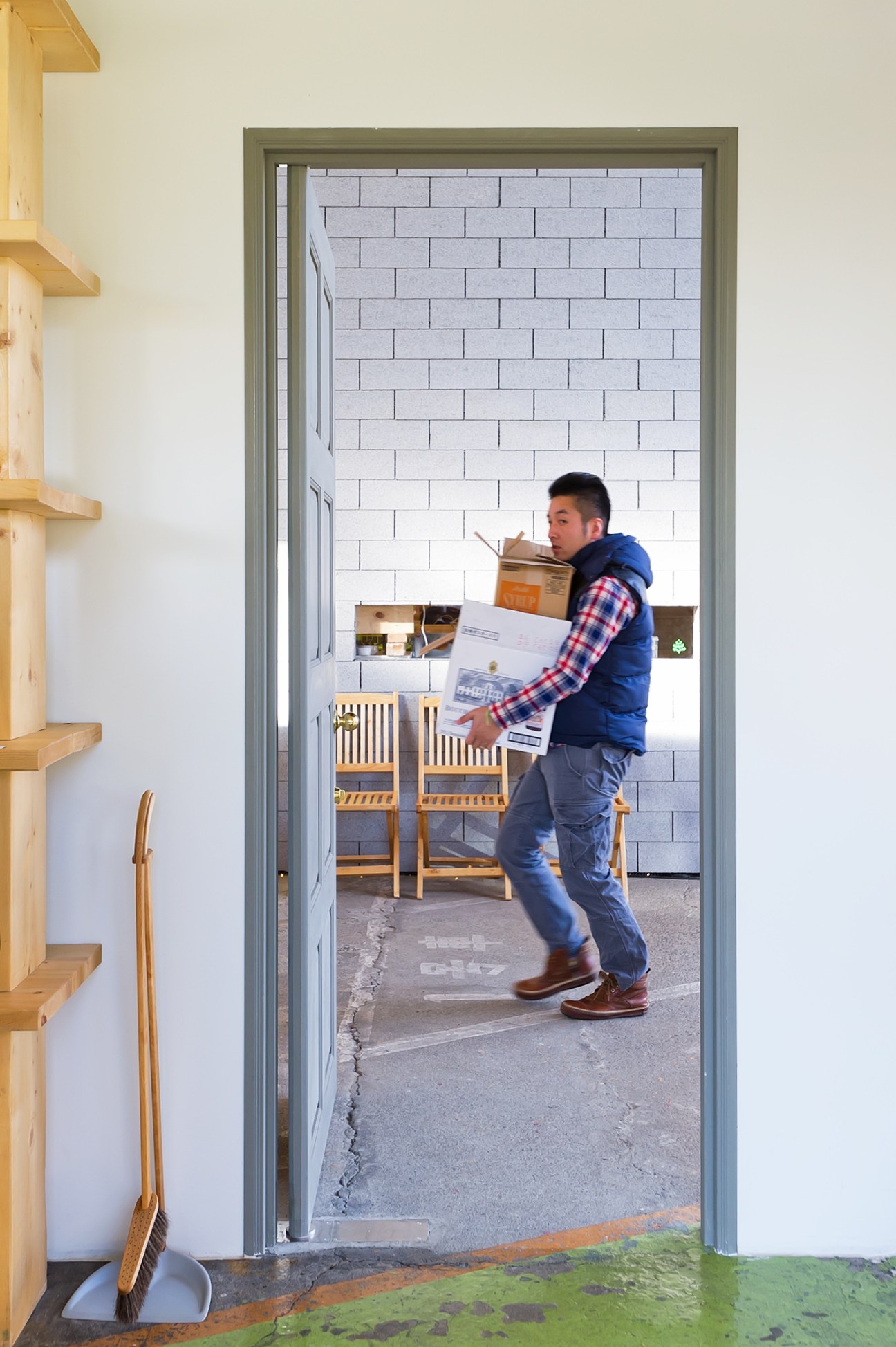 A man carries boxes through a doorway at Newland, a community development in Kumagaya, Japan.