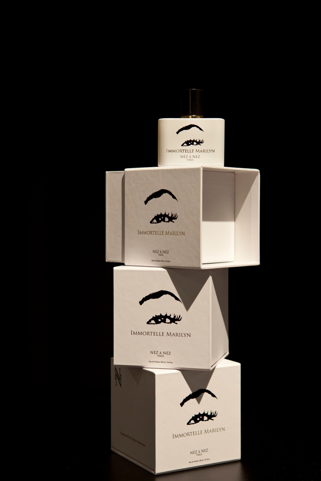 Stacked boxes and bottle of Immortelle Marilyn perfume by Nez à Nez with eye illustration on cream packaging.