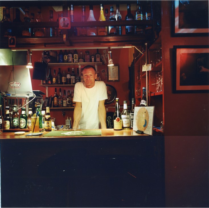 Mads Breyen, Danish owner of Moon Bar, stands behind the counter of his red-walled bar on Tanegashima.