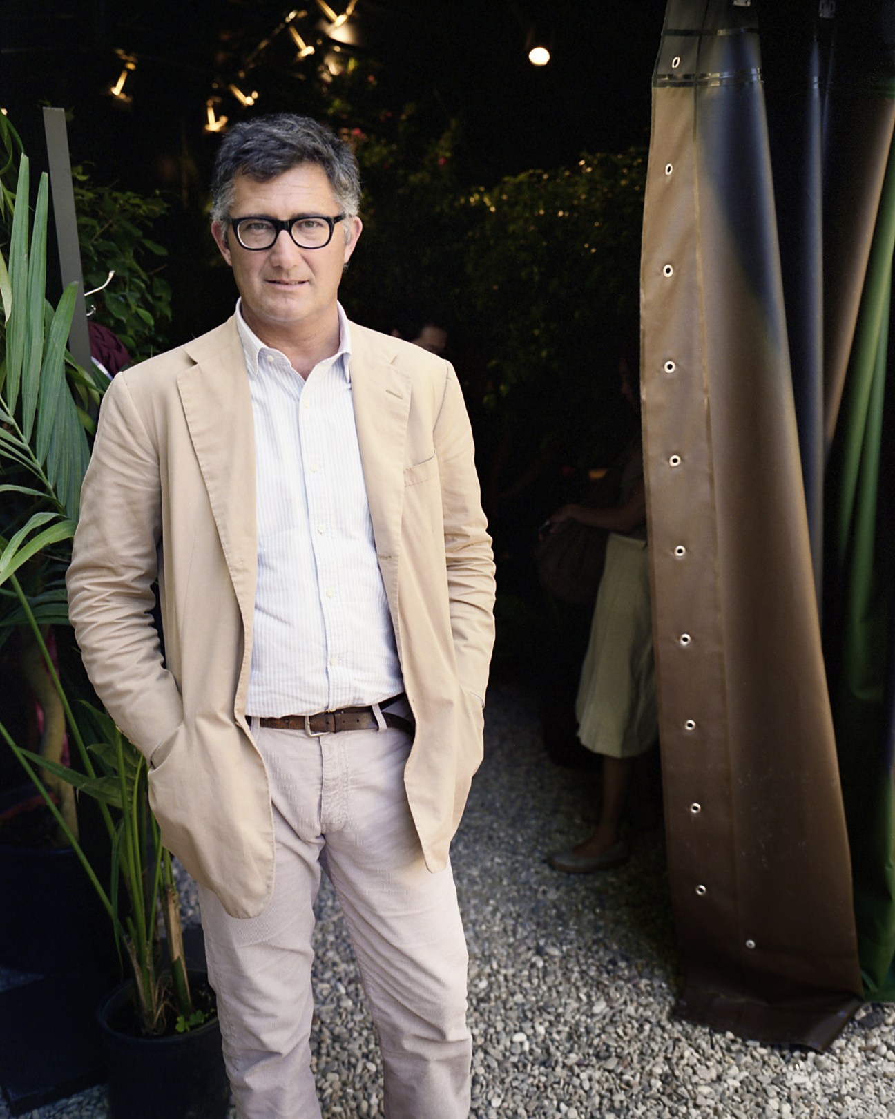 Massimo Piombo stands in a beige blazer and light shirt at his Pitti Uomo stand.