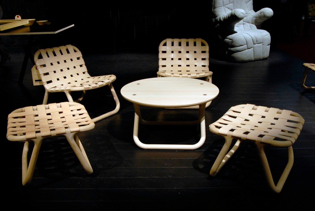Wooden chairs and table with woven seats from Normann Copenhagen's Camping collection displayed at Salone.