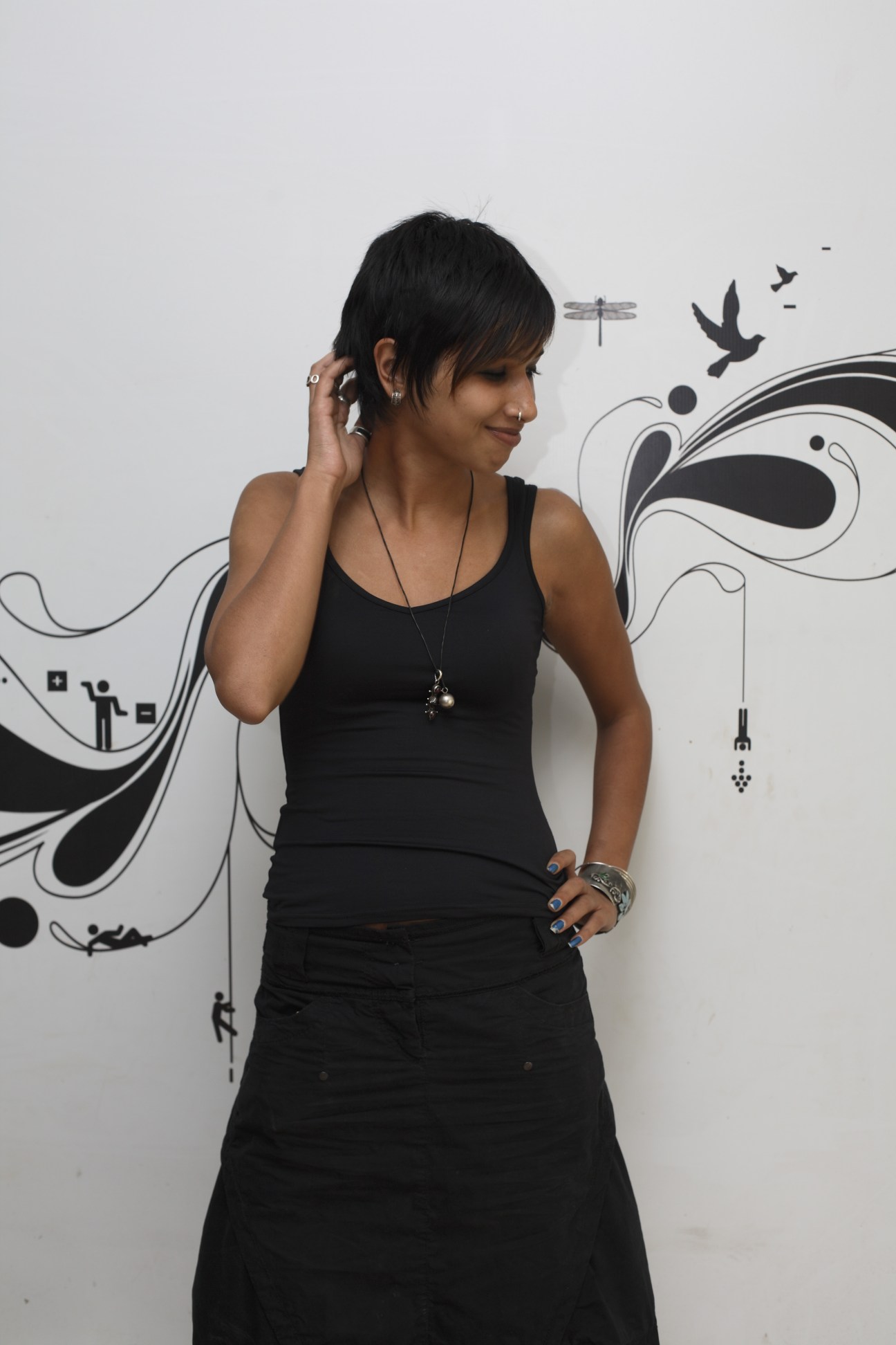 Diya Lahiri, senior film executive at Ogilvy, poses against a wall with decorative black and white graphic designs.