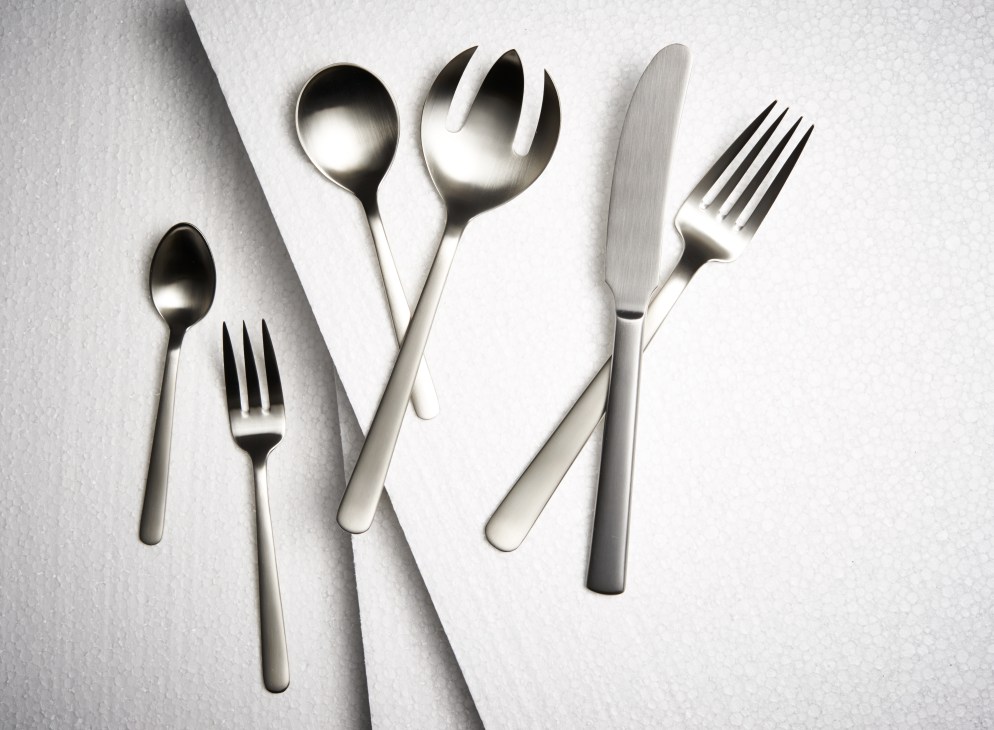 Kay Bojesen Grand Prix flatware set displayed on white surface showing spoons, forks and knife.
