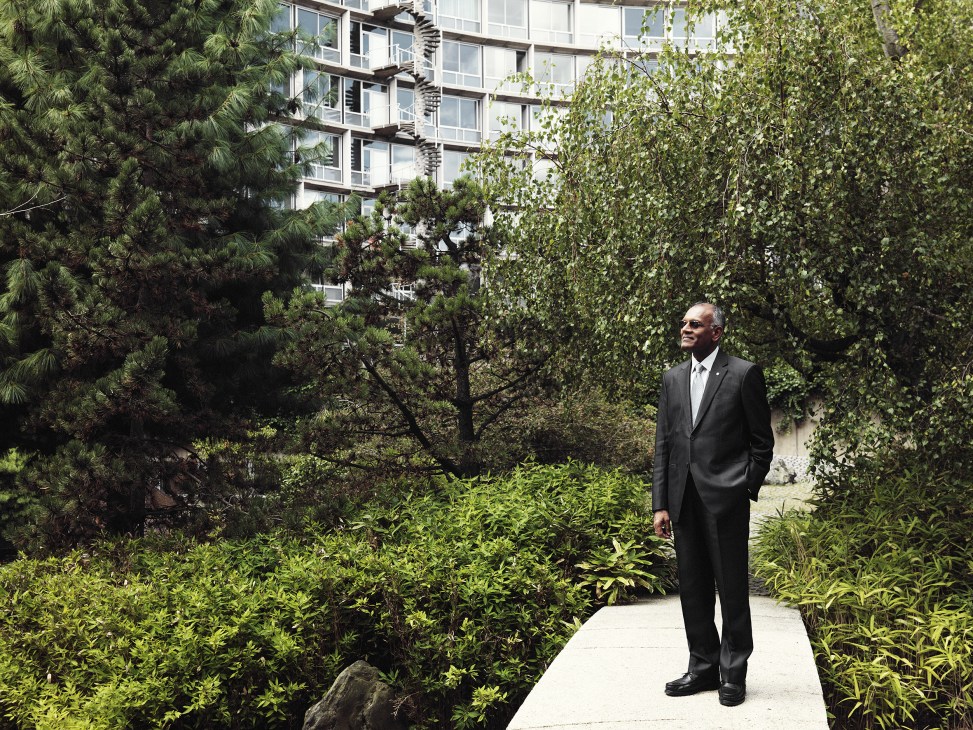 Kishore Rao, director of World Heritage Centre, stands in a lush garden with the Unesco building behind him.