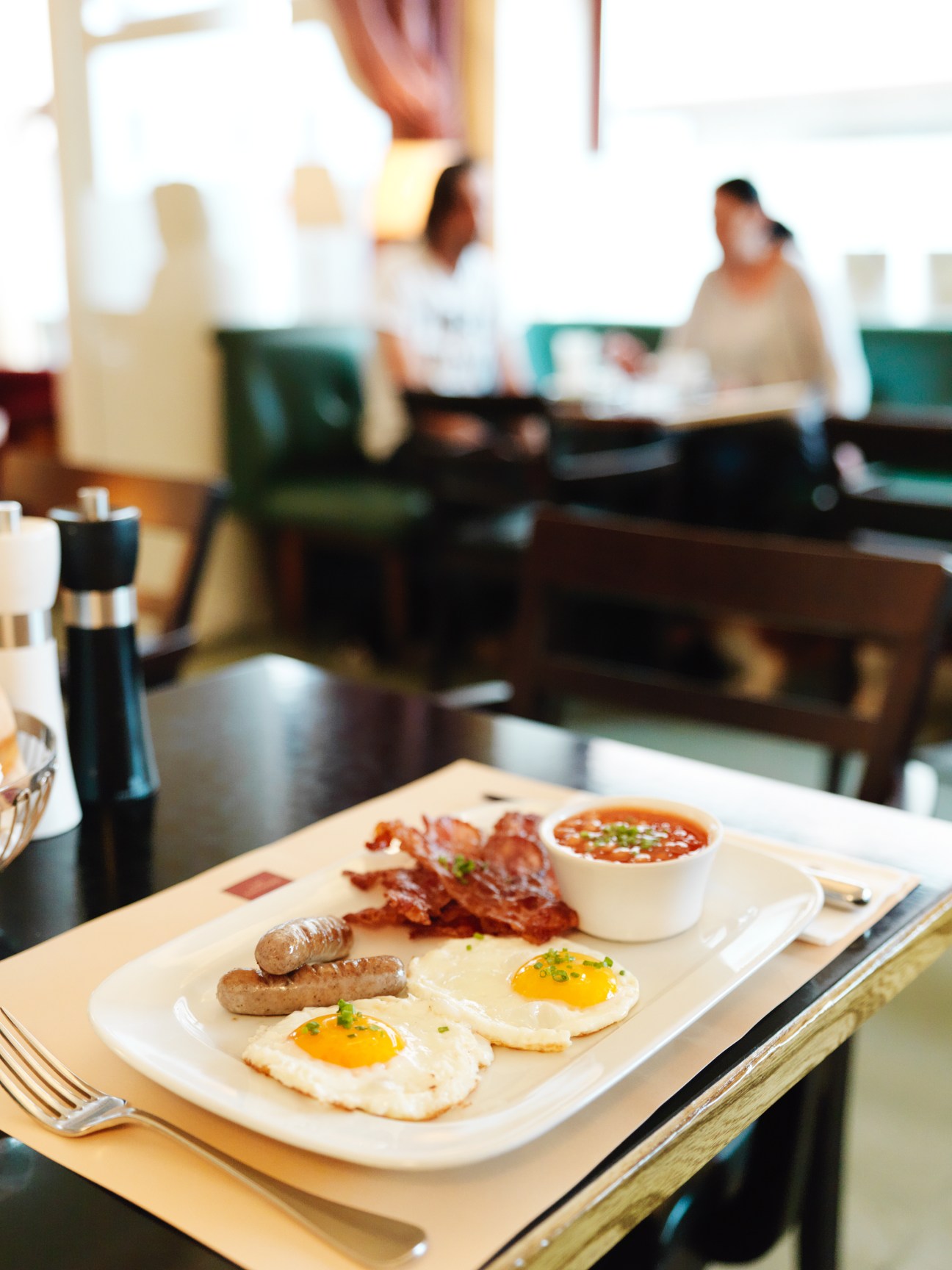 Breakfast plate with fried eggs, sausages and beans at Café Engländer in Vienna.