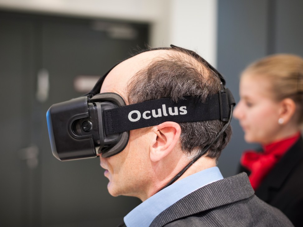 Man wearing Oculus virtual reality headset at InnoTrans trade fair booth.