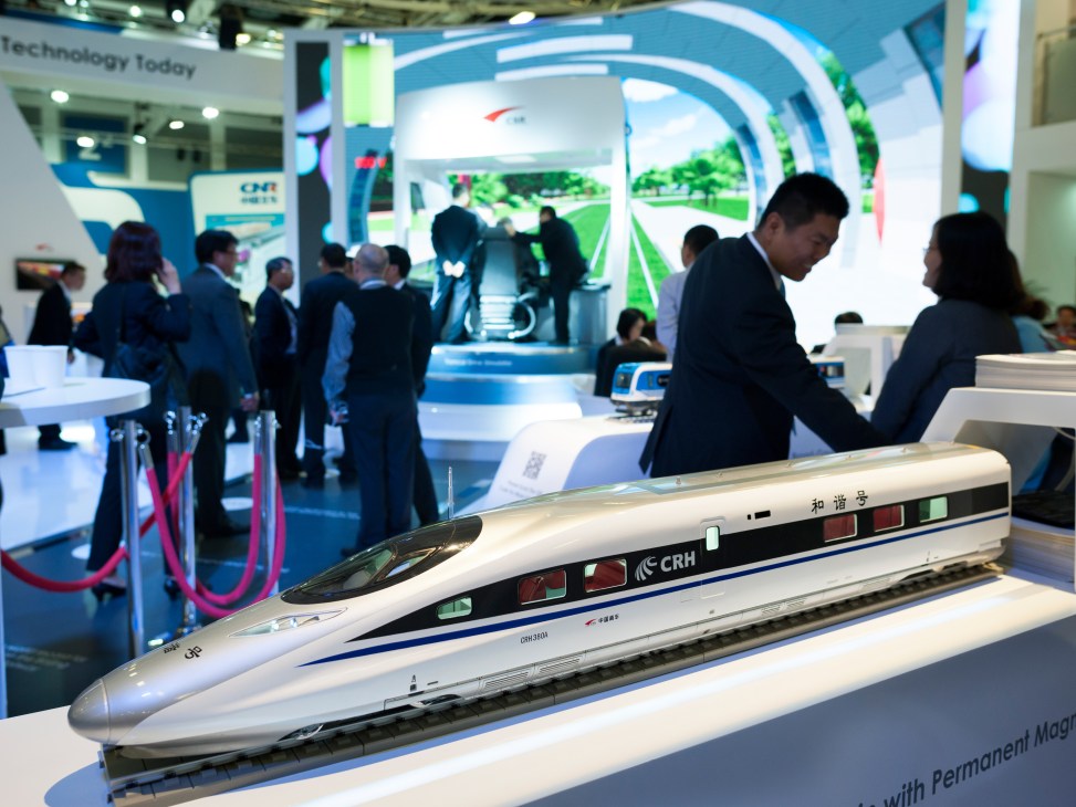 Model of a Chinese high-speed train displayed at InnoTrans trade fair with visitors in background.