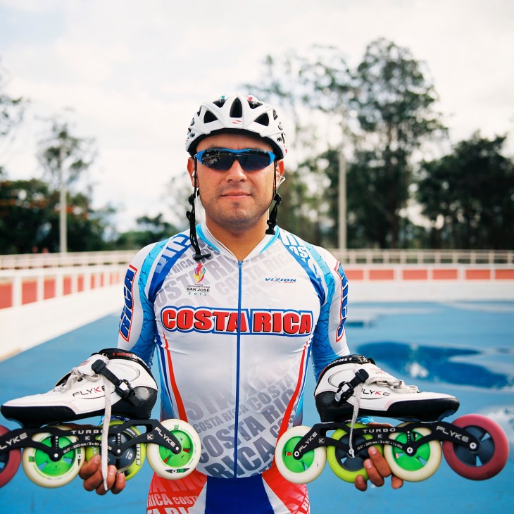 Champion speedskater Montoya Arcy poses with roller skates at an indoor skating rink.